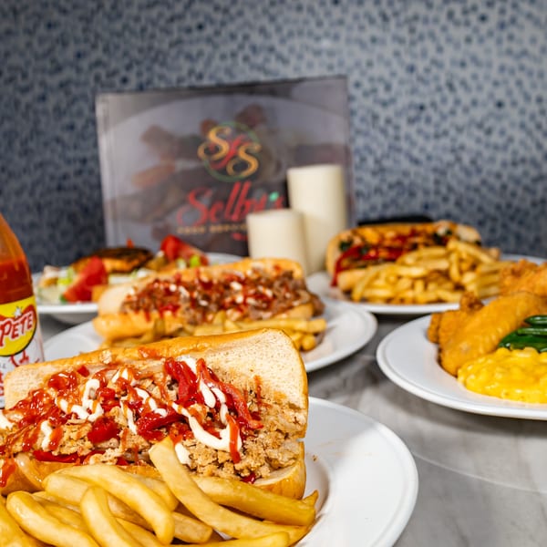 Selby's Grab and Go cheesesteak subs with fries, fried chicken, and hot sauce.